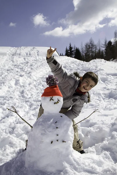 Bambino con pupazzo di neve — Foto Stock