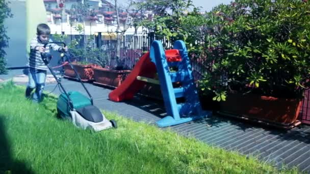 Bambino con tosaerba che lavora in giardino — Video Stock