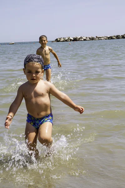 Criança feliz corre para o mar para nadar, férias na Itália — Fotografia de Stock