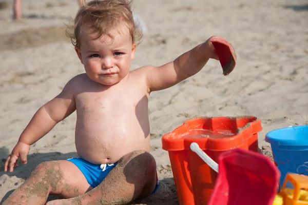 Niño jugando en la playa con cubo — Foto de Stock