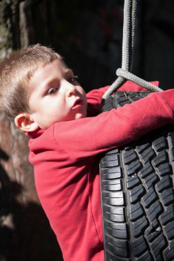 Çocuk otomobil lastiği ile yapılan salıncak üzerinde