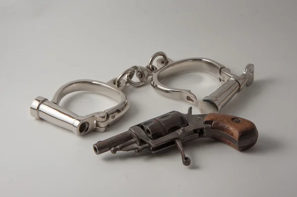 Old handcuffs and revolver — Stock Photo, Image