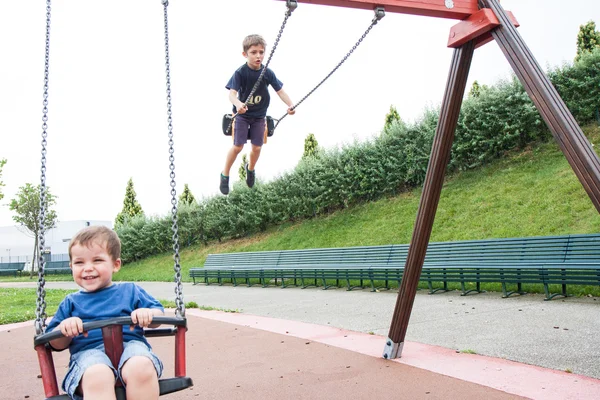 Zwei Kinder spielen in der Schaukel — Stockfoto