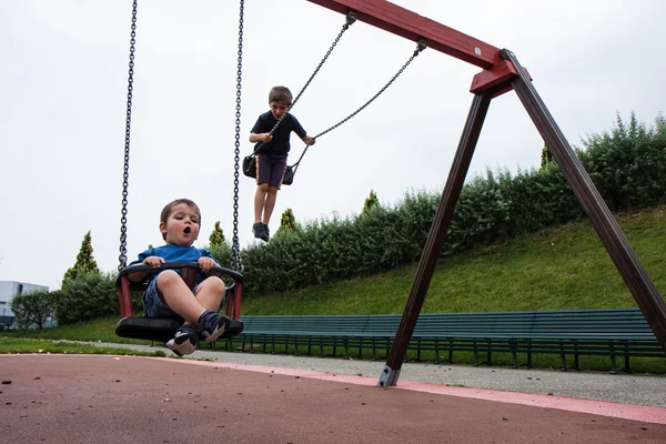 Zwei Kinder spielen in der Schaukel — Stockfoto