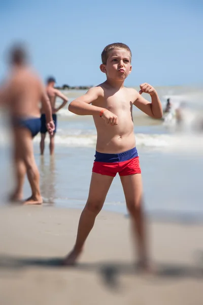 Feliz menino dança na praia no dia tempo — Fotografia de Stock