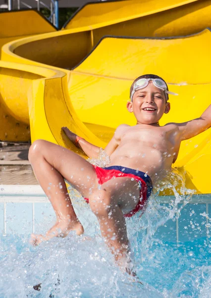 Criança brincando com o slide na piscina — Fotografia de Stock