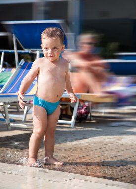 bir su birikintisine oynayan bebek