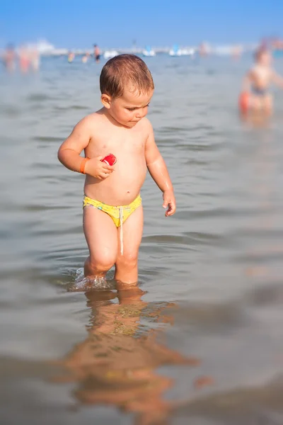 Bebé feliz jugando en el agua en la playa — Foto de Stock