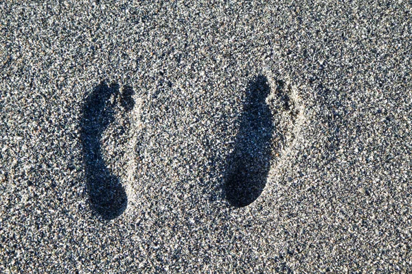 Huellas en la playa de piedras grises — Foto de Stock