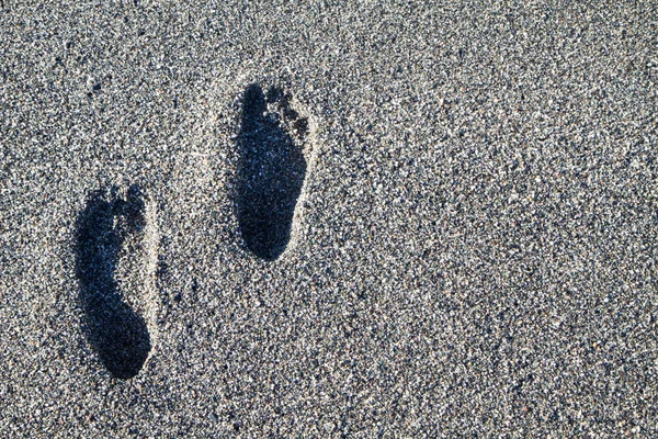 Huellas en la playa de piedras grises — Foto de Stock