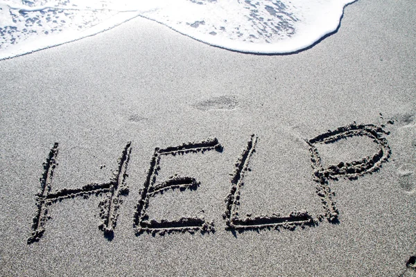 Words written on the pebble beach, help Stock Image