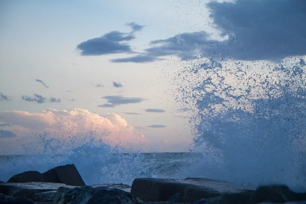 Wellen krachen auf die Buhne vor einem blauen Himmel bei Sonnenuntergang — Stockfoto