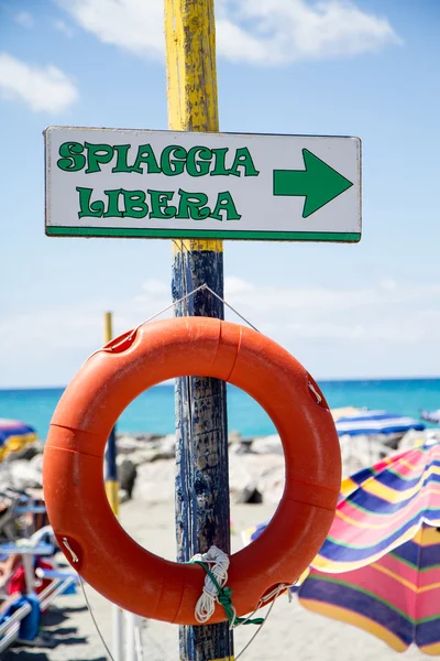 Playa libre, señal de indicador en el poste de madera con salvavidas — Foto de Stock