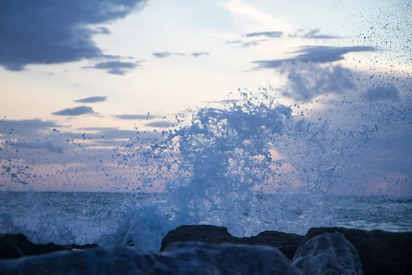 Wellen krachen auf die Buhne vor einem blauen Himmel bei Sonnenuntergang — Stockfoto