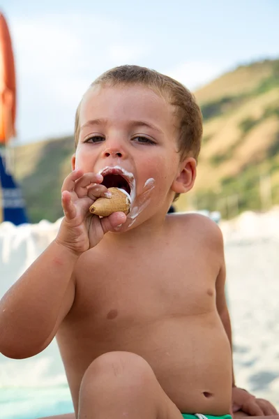 Baby, äta en glass på stranden — Stockfoto