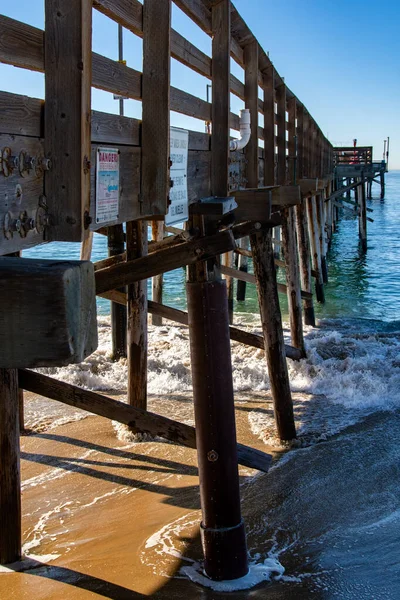 加州纽波特海滩的巴尔博亚码头 码头下面有水在旋转 该码头始建于1906年 直到1998年遭受风暴破坏后 其木制柱子才得到钢筋护柱和支撑物的加固 — 图库照片