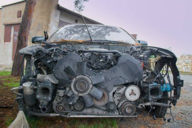 Garajın yanına park edilmiş bir araba kazası. Birisi onu yağmalamış ve parçaları çıkarmış..