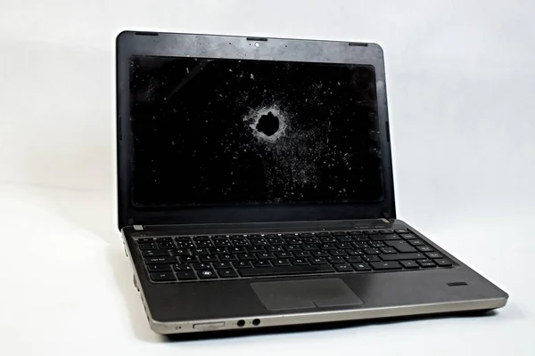Broken laptop screen. Computer insurance pays off.The black laptop screen has a huge hole in it.