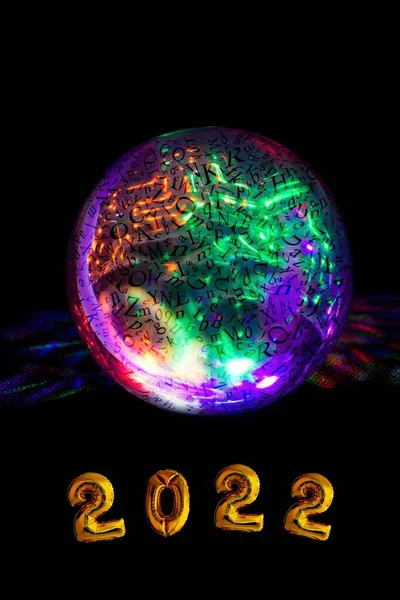 What will the year 2022 bring us? Happy New Year. Prophetic glowing sphere in the palm with the inscription 2022. Discover the future.