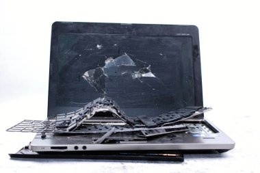 Laptop paramparça olmuş. Ekran çatlamış, klavye kırılmış. Elektro atık.