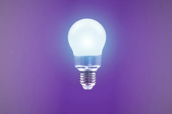 Leuchtende Energiesparlampe Auf Violettem Hintergrund Sparen Sie Strom Sparen Sie — Stockfoto