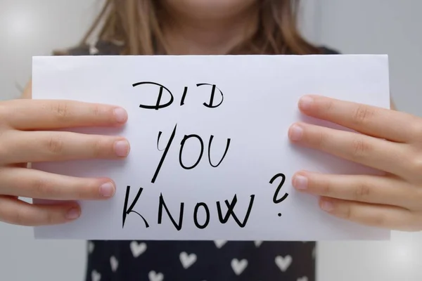 Girl or woman wearing a dress with a heart holding a sign saying Did you know?Concept on the topic Did you know? What you don`t talk about or what you don`t know.