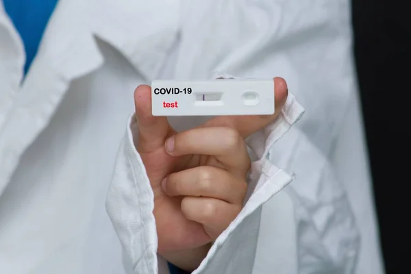 The doctor is holding a negative antigen test for covid.With this test, you can test yourself at home using saliva or a nasal swab.