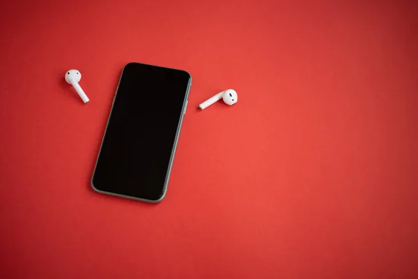 Ein Modernes Telefon Mit Zwei Drahtlosen Kopfhörern Den Seiten Auf — Stockfoto