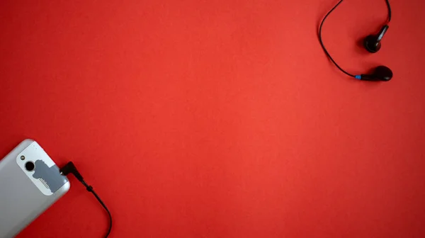 Alte Veraltete Und Verschlissene Mobiltelefone Und Kabelgebundene Ohrhörer Auf Rotem — Stockfoto