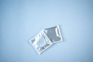 Mavi arka planda birkaç prezervatif var. Güvenli seks kavramı.