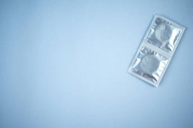 Mavi arka planda birkaç prezervatif var. Güvenli seks kavramı.