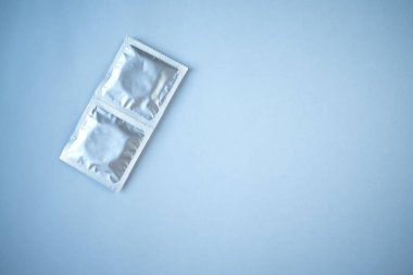 Mavi arka planda birkaç prezervatif var. Güvenli seks kavramı.