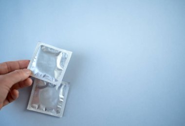 Mavi arka planda birkaç prezervatif var. Güvenli seks kavramı.