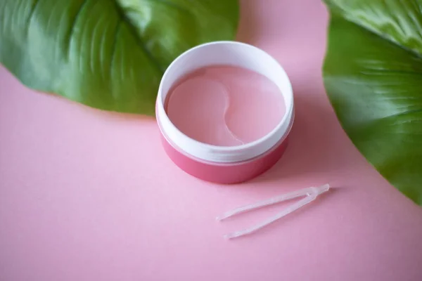 Pembe hidrojel göz bantları pembe arka planda. Banyo tedavileri. Ev yapımı yüz bakımı.