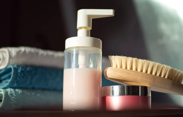Banyo tesisleri ve banyoda bir yığın temiz havlu. Kuru masaj için ahşap fırça, sıvı sabun ve vücut kremi.
