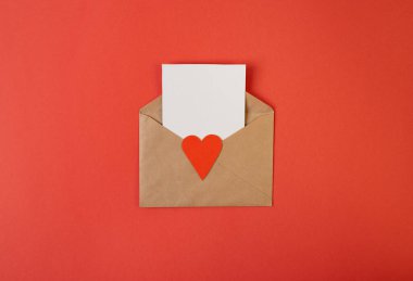 İçinde beyaz notlar olan bir zarf ve kırmızı arka planda sevgililer günü kalpleri. Düz yerde, üst tarafta. Sevgililer Günü konsepti için romantik aşk mektubu.