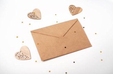 Ahşap kalpli el işi zarf ve arka planda küçük altın yıldızlar. Düz yerde, üst tarafta. Sevgililer Günü konsepti için romantik aşk mektubu.