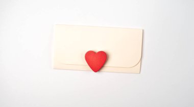 Beyaz arka planda zarf ve kırmızı kalp. Düz yatıyordu. Sevgililer Günü konsepti için romantik aşk mektubu.