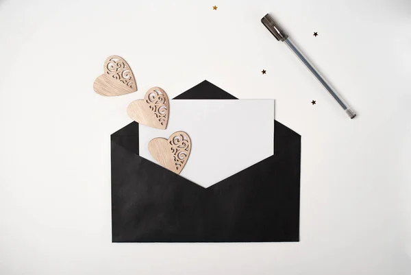 Schwarzer Umschlag Mit Einem Leeren Blatt Papier Inneren Und Holzherzen — Stockfoto