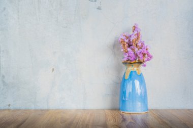 Çimento duvar geri ahşap bir masada mavi vazoda Pembe çiçek