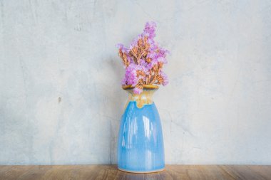 Çimento duvar geri ahşap bir masada mavi vazoda Pembe çiçek