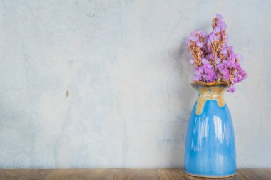 Çimento duvar geri ahşap bir masada mavi vazoda Pembe çiçek