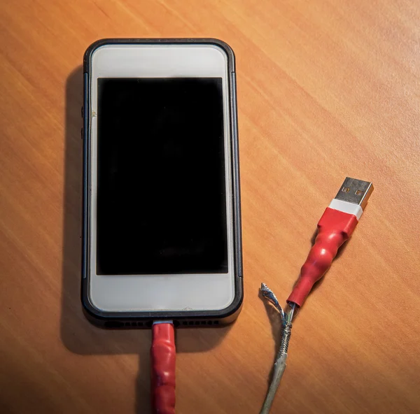 Gebroken USB-kabel van de lader op houten achtergrond — Stockfoto