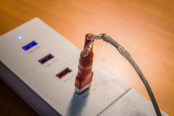 Zlomený kabel usb nabíječka USB nabíjení s dřevěnou pozadí — Stock fotografie