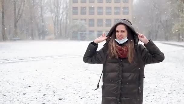 The girl rejoices at the first snow, is spinning, the mask is removed from her face — Stock Video