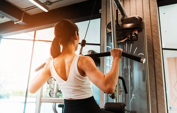 Cerca Espalda Mujer Joven Ropa Deportiva Haciendo Ejercicio Con Máquina — Foto de Stock