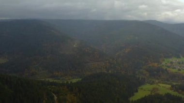 Sonbaharda ağaçların, tepelerin ve dağların havadan görünüşü bulutlu bir günde Almanya 'daki kara ormana düşer..