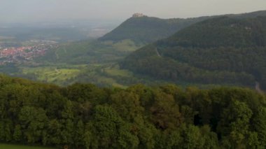 Almanya 'da Neuffen köyü ve şatosunun hava görüntüsü bulutlu bir sabah erken saatlerde Burg Hohenneuffen. 