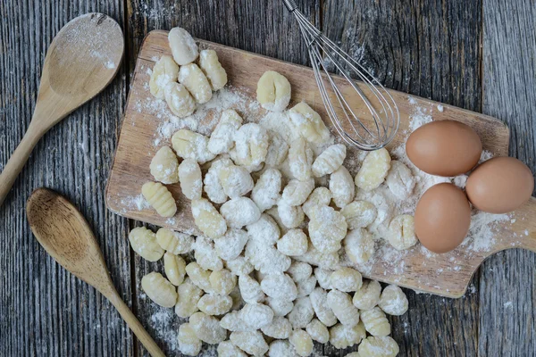 Gnocchi op snijplank en rustieke houten achtergrond — Stockfoto