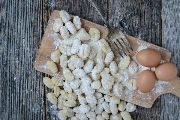 Gnocchi op snijplank en rustieke houten achtergrond — Stockfoto